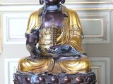 une statue de Bouddha assis sur une table rouge