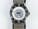 a watch that is sitting on top of a gray strap