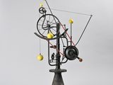 an image of a sculpture of a spinning machine with yellow balls
