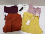 three pairs of shorts and a t - shirt sitting on a table