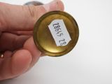 a person holding a small brass object with a tag on it