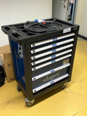 un chariot à outils noir sur lequel se trouvent tout un tas d'outils