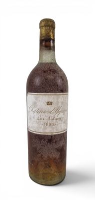 an old bottle of wine sitting on top of a white surface