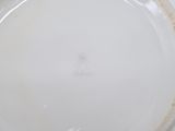 a white plate with a brown rim on a table