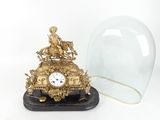 une horloge en or surmontée d'un dôme en verre