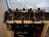 beaucoup de téléphones qui prennent la poussière sur une étagère