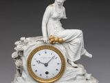 une horloge blanche et dorée sur laquelle est assise une femme