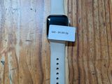 une Apple Watch posée sur un parquet, à côté d'une table en bois