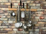 a brick wall with a bunch of kitchen utensils hanging on it