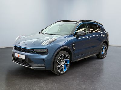 Le SUV bleu est garé dans une grande pièce au sol noir.