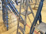many ladders that are sitting on the floor in a warehouse