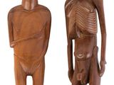 deux figurines en bois représentant un homme et une femme debout l'un à côté de l'autre
