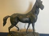 statue of a horse running on a black surface