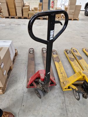 un chariot élévateur et une palette dans un entrepôt rempli de cartons