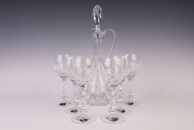 six verres à vin et une carafe posés sur une table