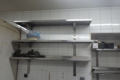 a kitchen with a lot of stainless steel shelvings on the wall