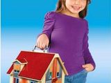 the little girl is holding a toy house in her hand