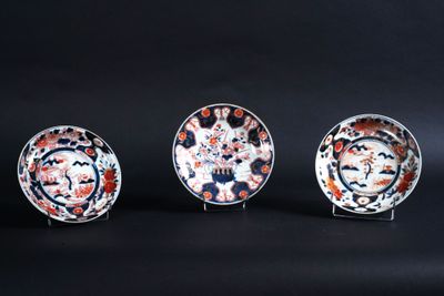 trois assiettes ornées de motifs différents, posées sur une surface noire
