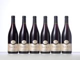 six bottles of wine lined up in a row on a table