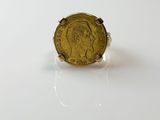 an image of a ring with a gold coin on it