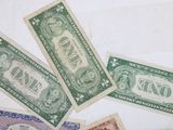 several bills of different colors and shapes on a white surface