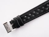 black leather watch strap with silver buckle on a white surface