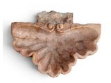a stone sculpture of a bird on a white surface