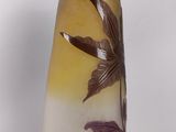 a glass vase with a design of leaves and flowers on it
