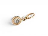 a close up of a gold and diamond charm on a white background
