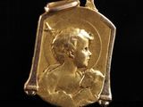 un gros plan d'une médaille d'or sur laquelle figure l'image d'un enfant