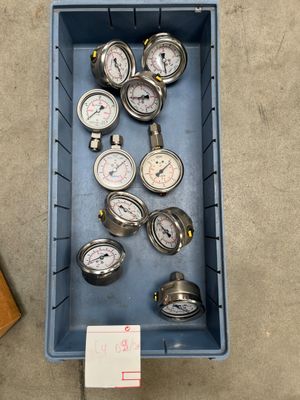 many gauges in a blue container on the floor