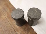 two salt and pepper shakers sitting on a wooden table