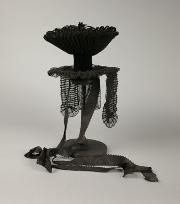 une sculpture représentant un oiseau posée sur un socle et entourée d'une chaîne
