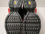 the soles of a pair of black and red shoes on a white surface