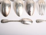 a lot of silver spoons and forks on the table