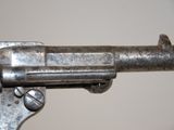 a close up of a gun on a white surface
