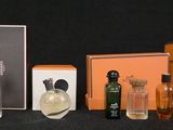 an assortment of perfume bottles and a box on a black surface
