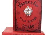 trois livres rouges empilés les uns sur les autres sur une surface blanche
