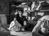 black and white photograph of a man sitting on a bed next to a woman
