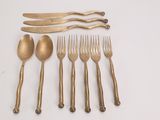 five forks, two spoons, and a knife on a table