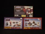 three boxes of action figures are shown on a black surface