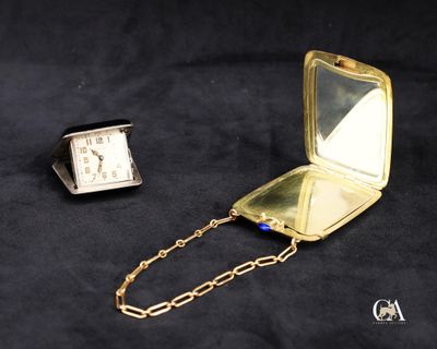 une montre de poche en or, entourée d'une chaîne, sur fond noir