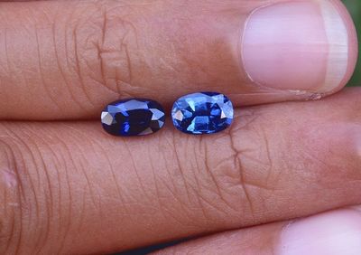 quelqu'un tient dans sa main une paire de saphirs bleus