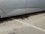 a silver car parked in a parking lot next to a building