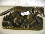 statue en bronze représentant un chien portant une médaille à son collier
