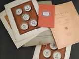 trois livres posés sur une table, sur laquelle se trouvent une horloge et un livre posé dessus