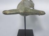 sculpture of a dolphin on a black stand on a white background