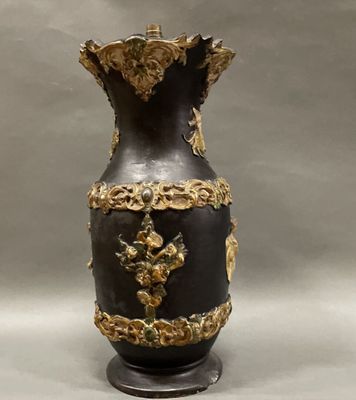a black and gold vase sitting on a stand