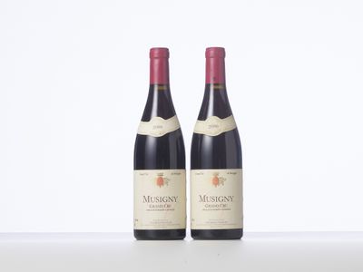 two bottles of red wine sitting next to each other on a table