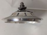 a silver plate with a bird on it hanging from the ceiling